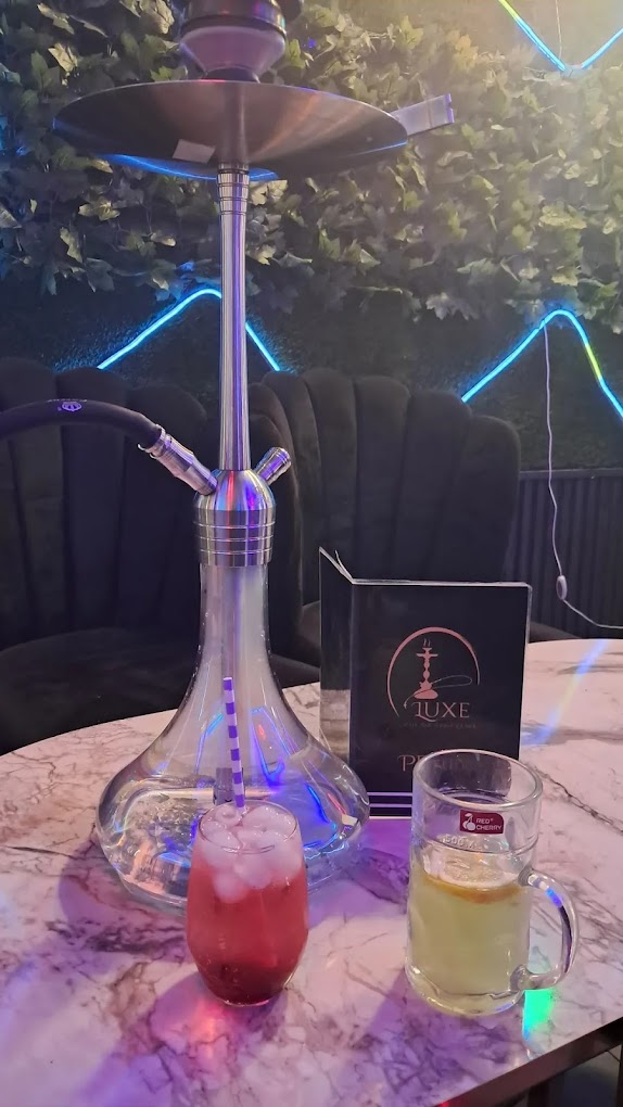 Shisha mit Getränken und Luxe-Karte vor der Neon-Wand in der Luxe Shisha Lounge