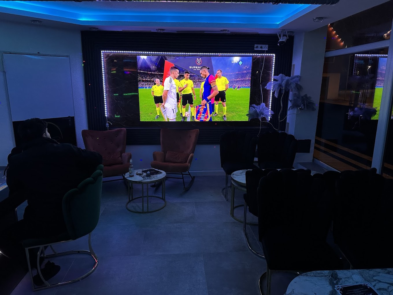 Lounge-Bereich mit großer Leinwand und Live-Sport in der Luxe Shisha Lounge